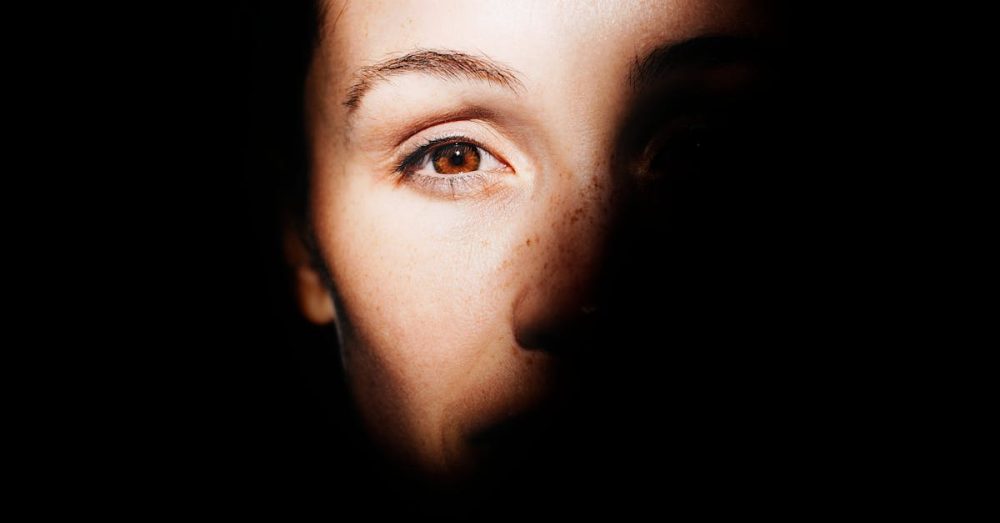 A striking portrait highlighting a woman's eye with dramatic light and shadow play.